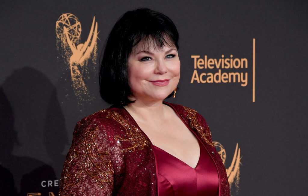 Delta Burke smiling in a red outfit